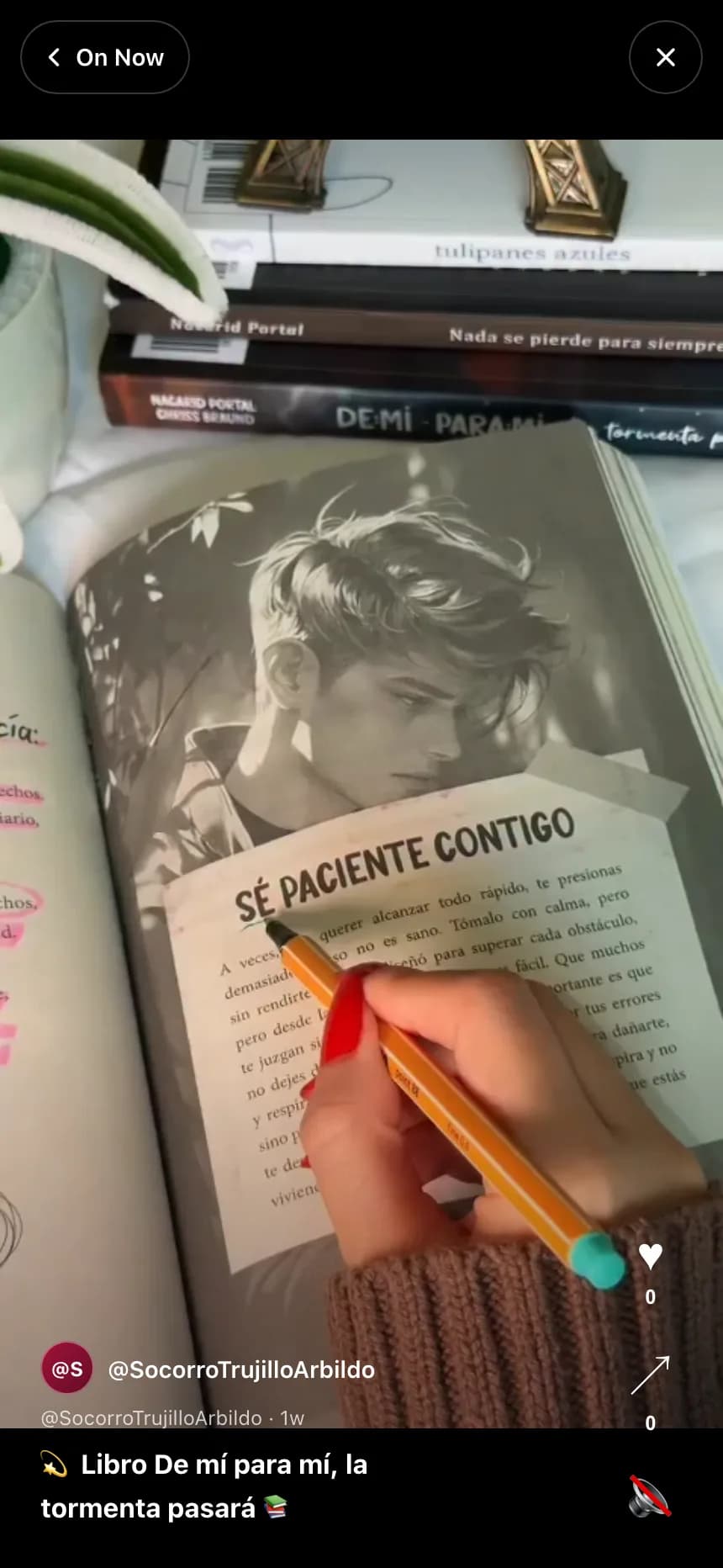 The Feed on a phone-sized screen: a vertical clip of a hand holding a pen over an open book, an On Now button in the top left, an X button in the top right, a heart with a 0 count and a share arrow with a 0 count on the right edge, a creator handle and a 1w timestamp, a Spanish caption, and a muted speaker icon in the lower right